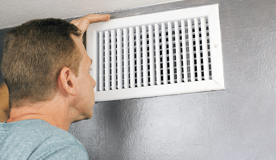 Man looking at vent | Stiles Heating, Cooling, & Plumbing
