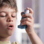 Boy with asthma inhaler | Stiles Heating, Cooling, & Plumbing