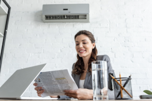 woman in the office with an AC unit above her