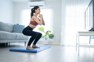 woman working out at home with an AC in the background